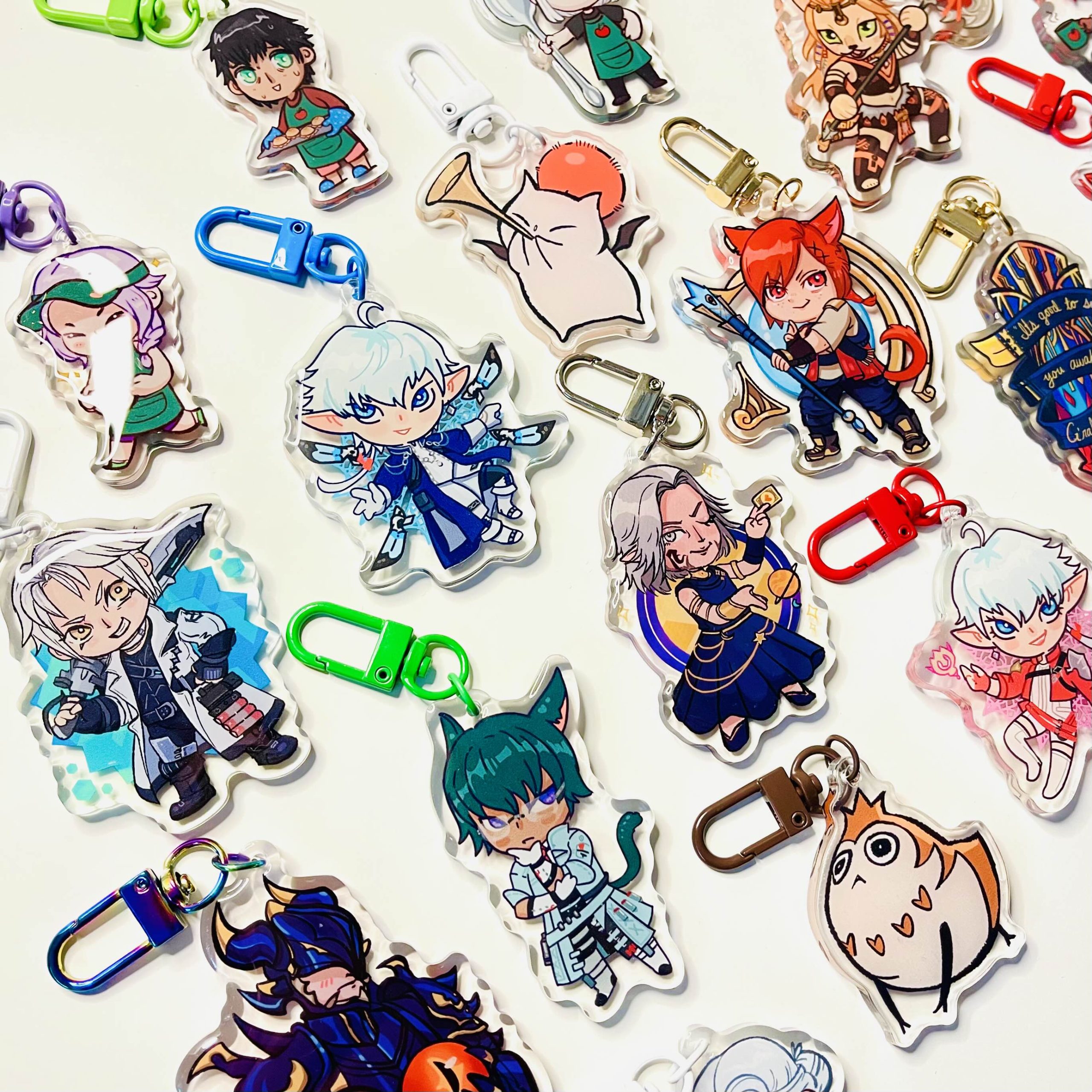 Assorted chibi-style fantasy character acrylic keychains with colourful clips arranged on a white background.