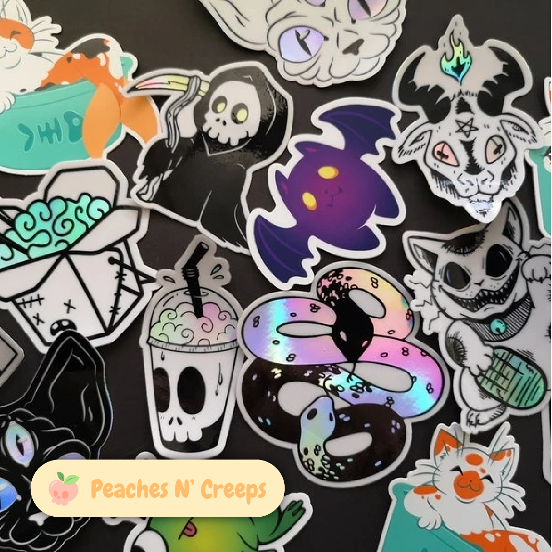 Close-up of Peaches N’ Creeps stickers featuring spooky-cute cats, ghosts, skulls, bats, drinks, snakes, and other creepy-cute designs.