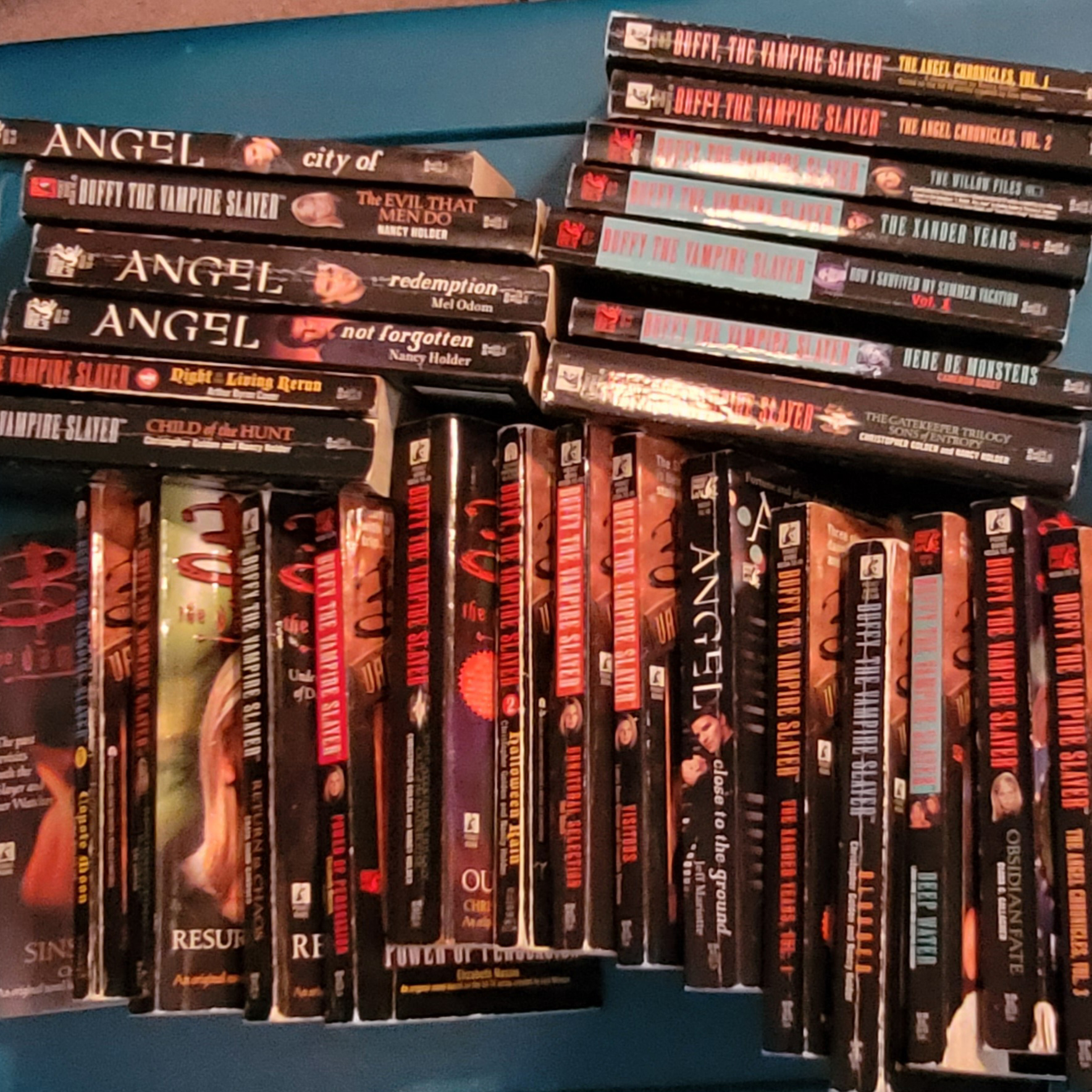Collection of Buffy the Vampire Slayer and Angel paperback books stacked with their spines facing outward.