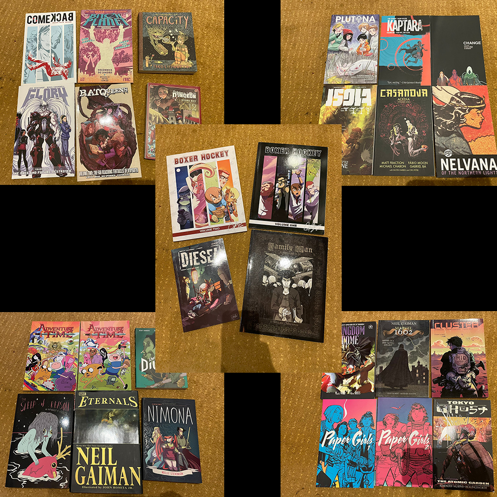 Collage of used graphic novels, comics, and manga arranged on a carpet, including Adventure Time, Nimona, Eternals, Paper Girls, Kingdom Come, and other titles.